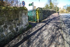 Entrance to narrow path by railway bridge